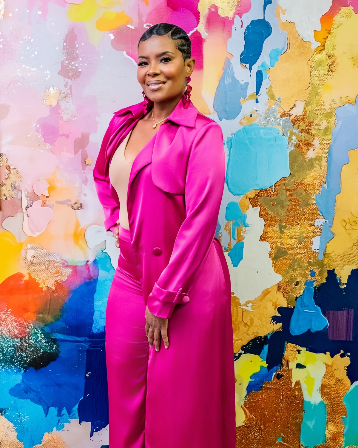 Elite practitioner in front of colorful artwork at the spa